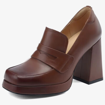 Un mocasín de tacón de piel para mujer de color marrón sobre un fondo blanco