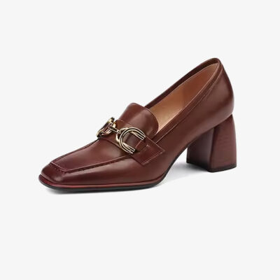 Un mocasín de tacón de cuero estilo vintage para mujer de color marrón sobre un fondo blanco uniforme