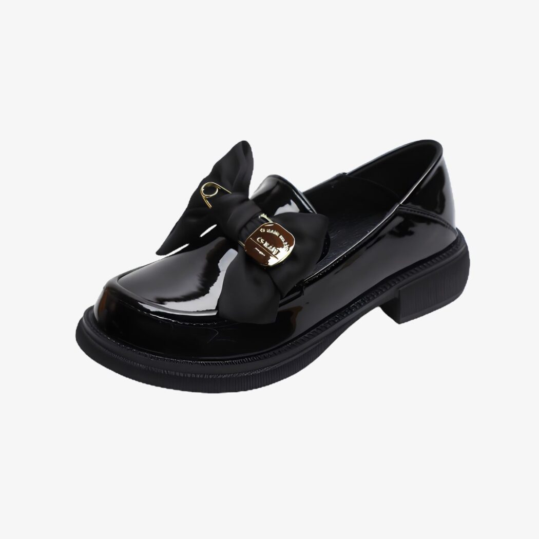 Mocassins à semelle épaisse à noeud papillon et épingle noir vernis sur fond gris très clair